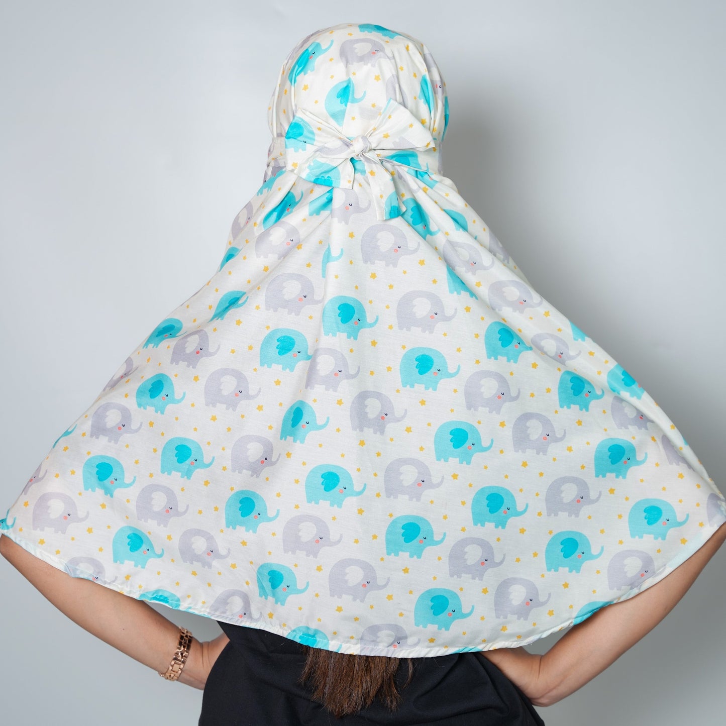 Person wearing a patterned headscarf with blue and gray elephants on a white background