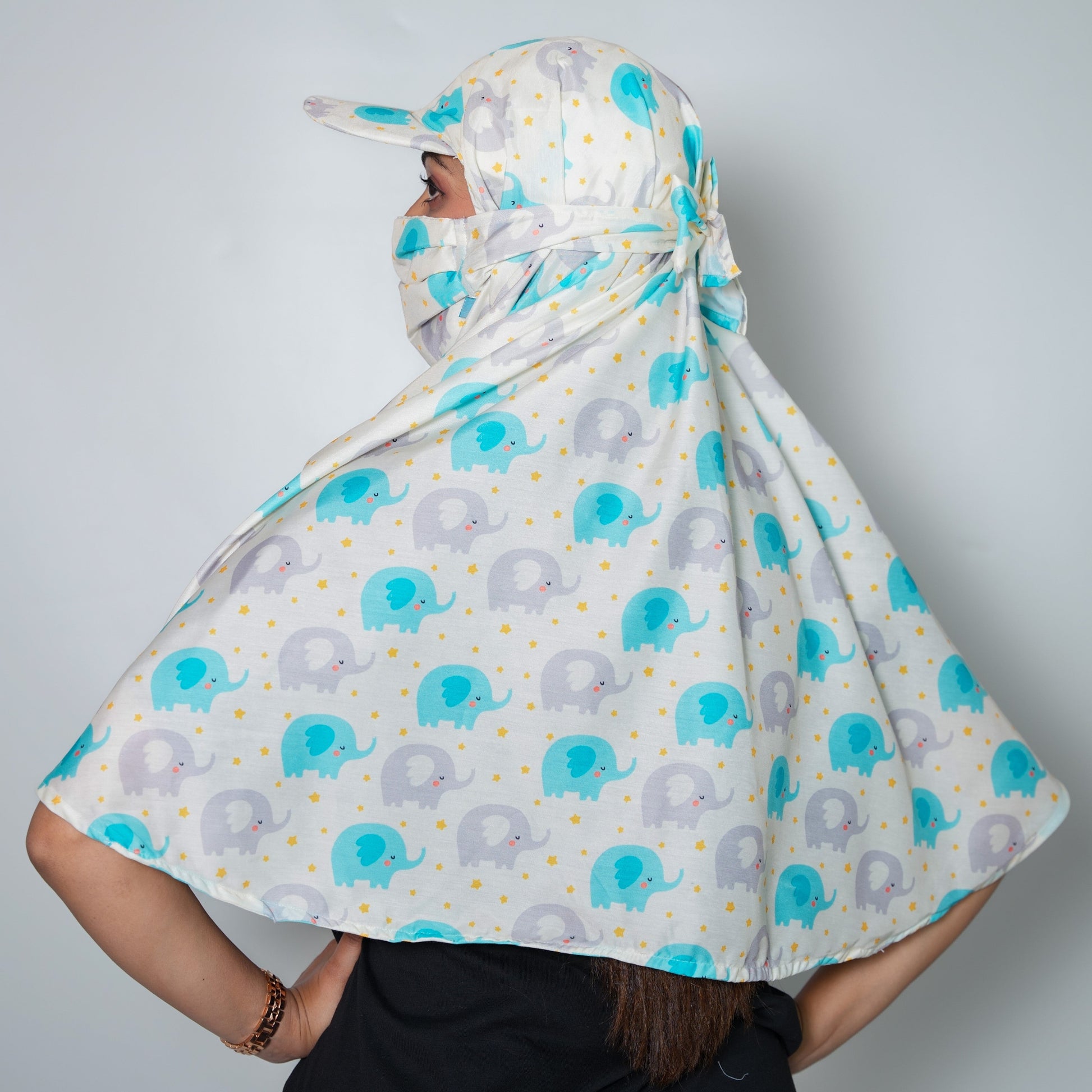 Person wearing a patterned headscarf with elephants on a plain background