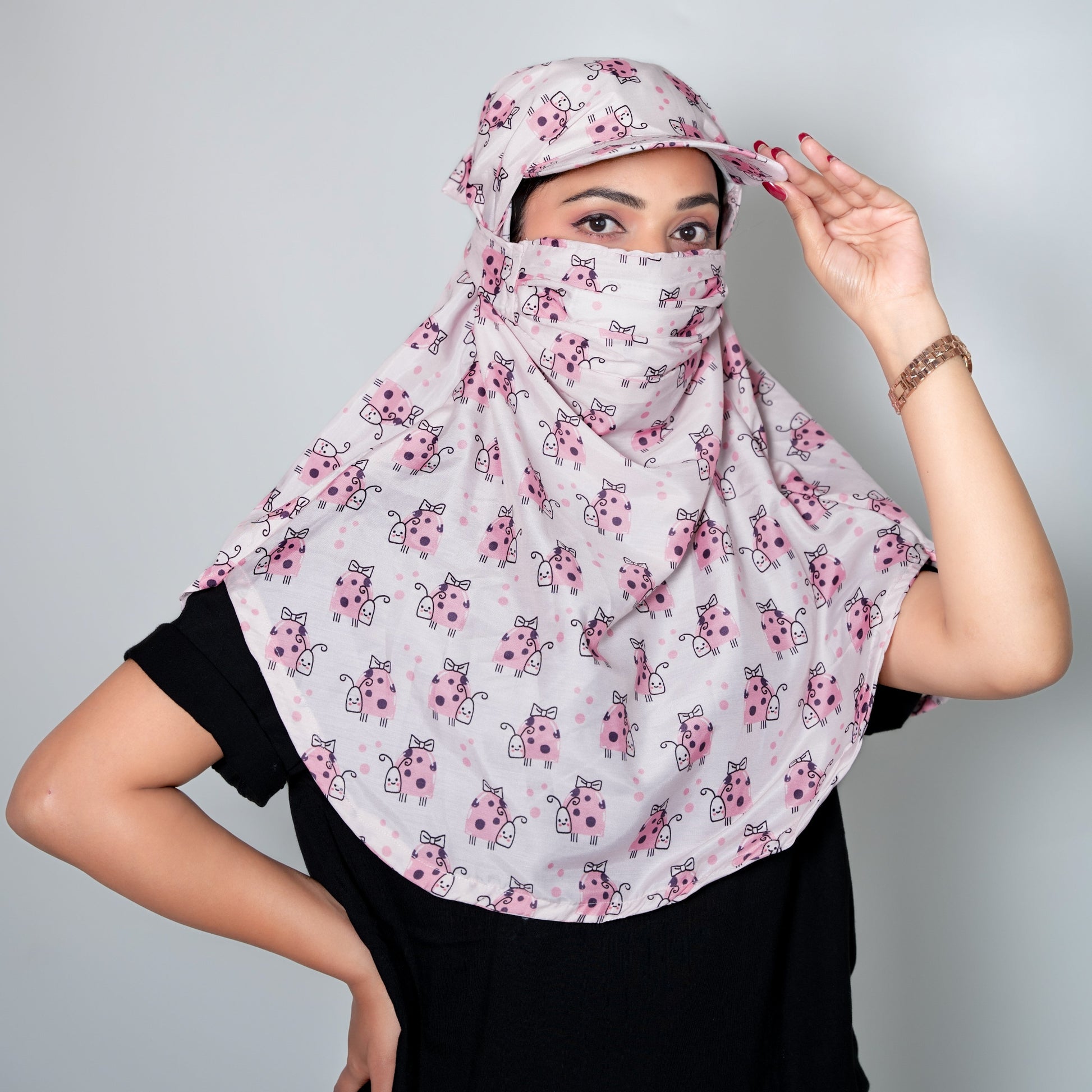 Woman wearing a floral headscarf and face cover against a gray background