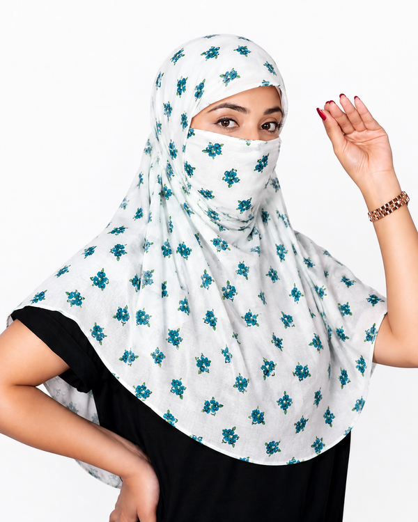 A woman wearing a white scarf with a teal floral pattern, paired with a black top, against a plain white background.