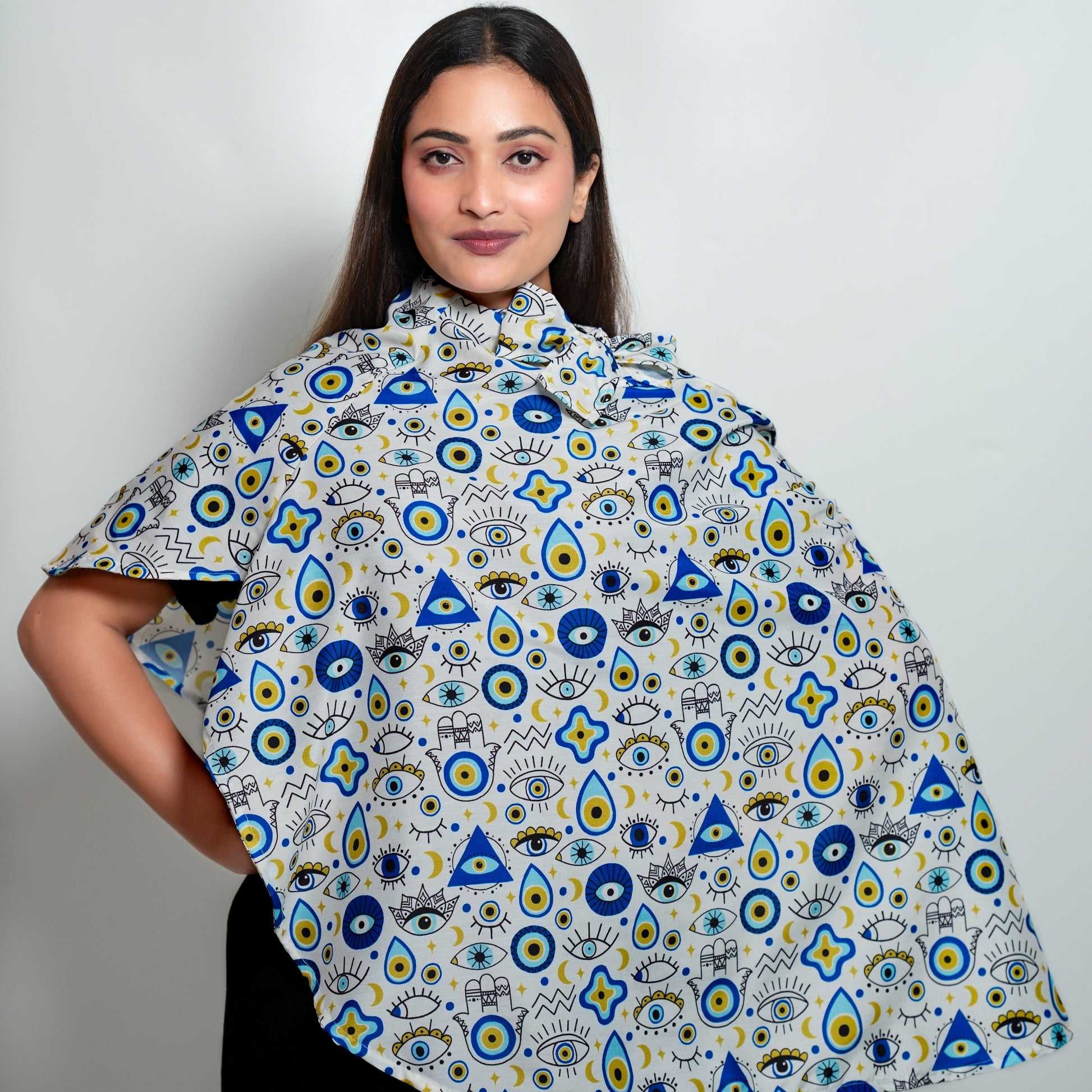 Woman wearing scarf cum poncho with geometric designs on a plain background