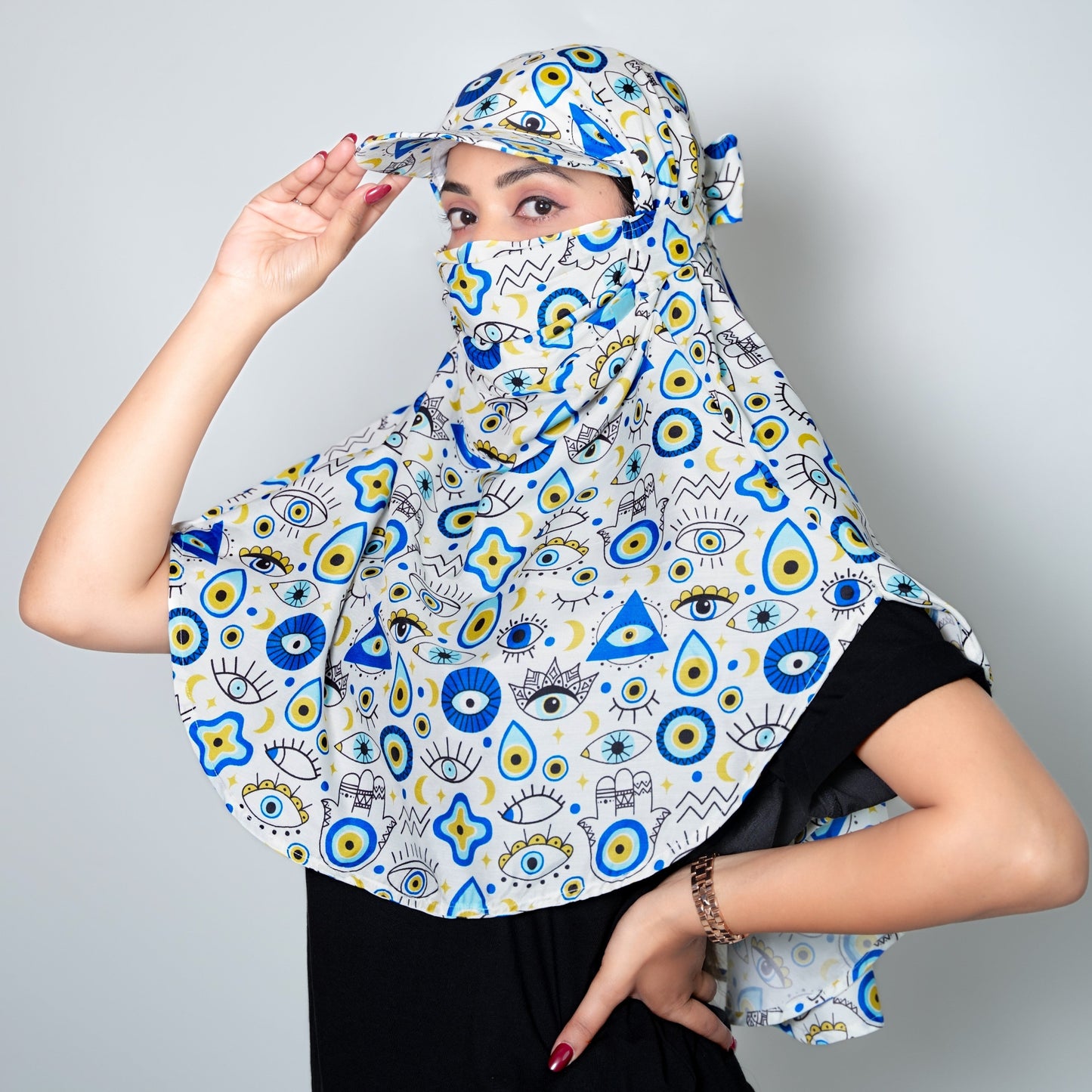 Women wearing a patterned cap scarf with blue, yellow, and black design on a gray background
