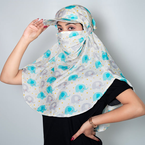 Person wearing a patterned headscarf with elephants and blue circles on a plain background