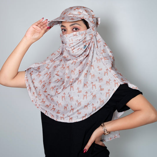 Woman wearing a patterned headscarf and cap against a plain background