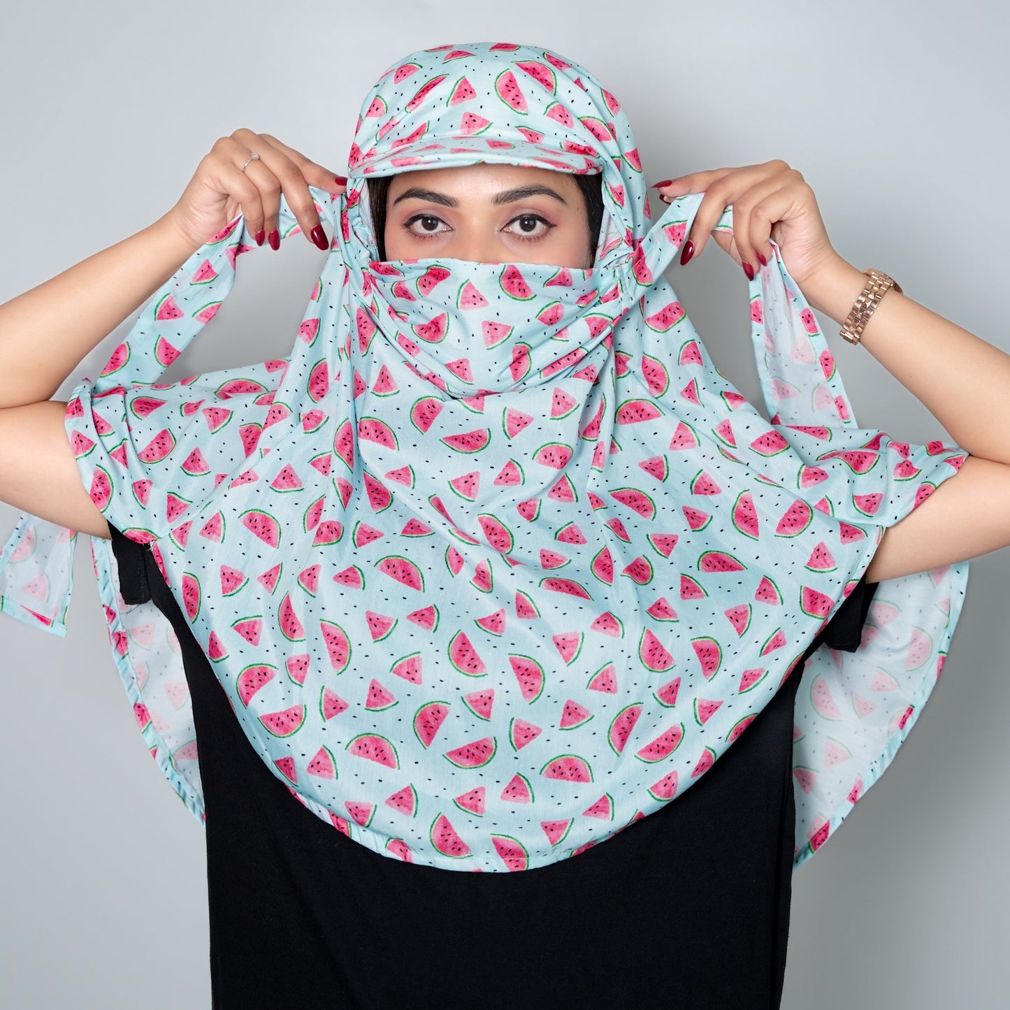 Person wearing a watermelon patterned scarf against a plain background