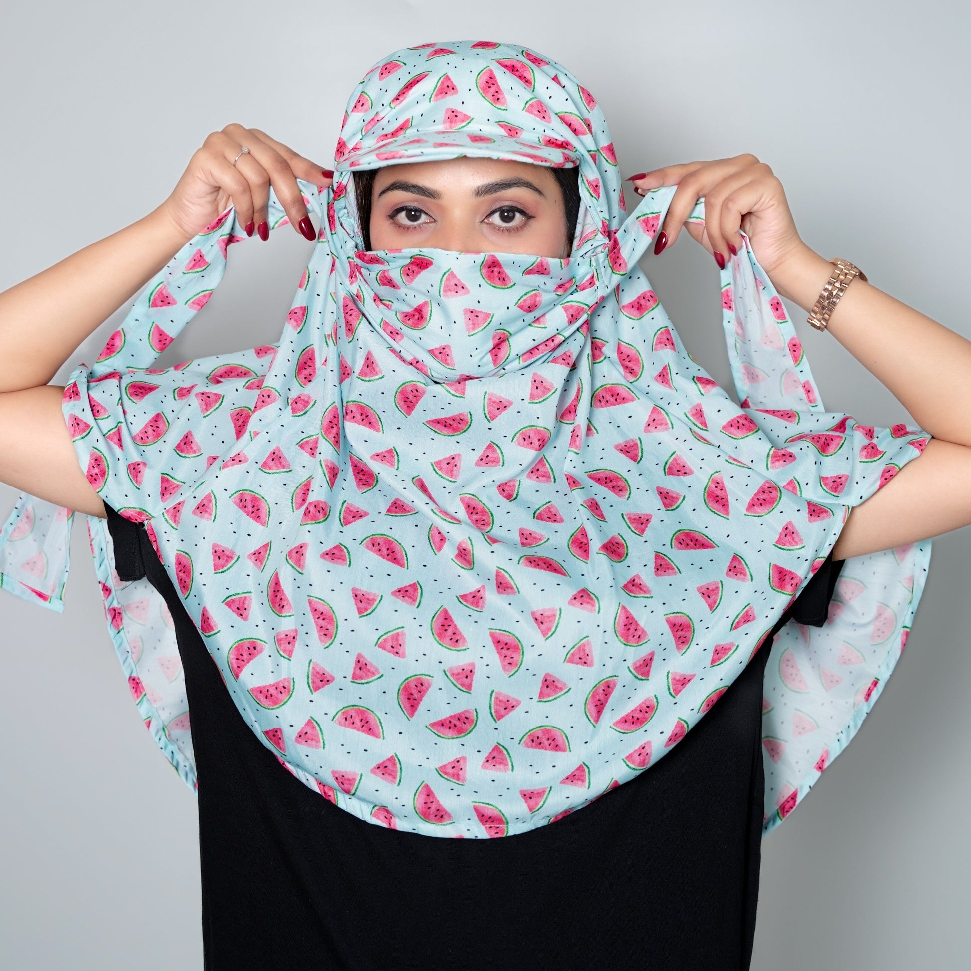 Person wearing a watermelon patterned scarf against a plain background