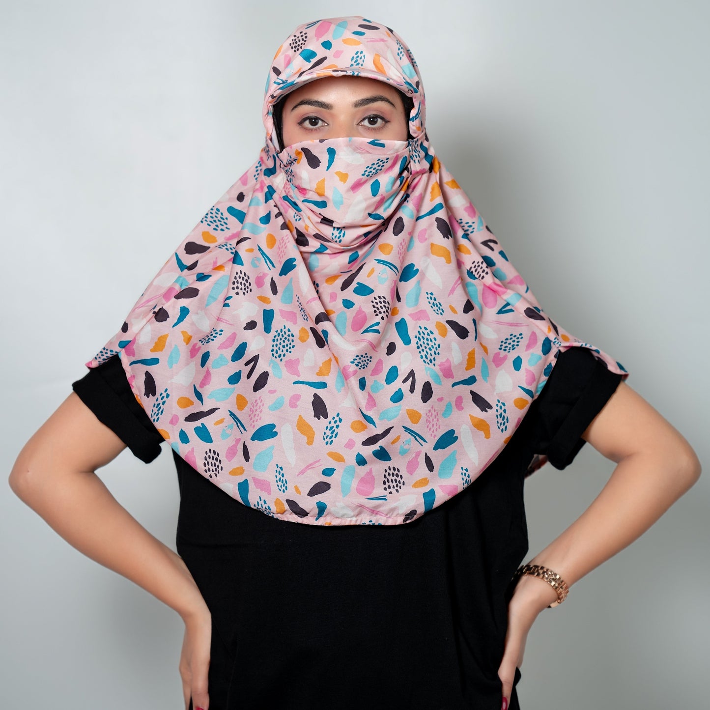 Woman wearing a colorful patterned cap scarf against a plain background