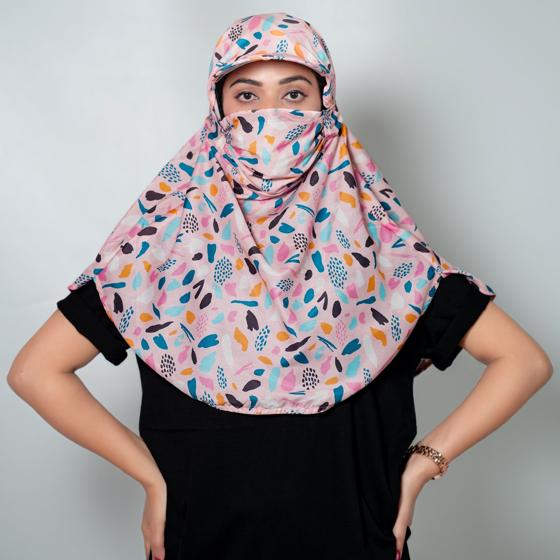 Woman wearing a colorful patterned cap scarf against a plain background